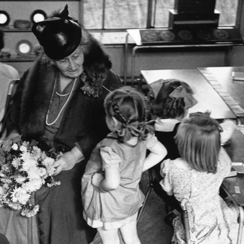 mari amontessori com crianças em sala de aula